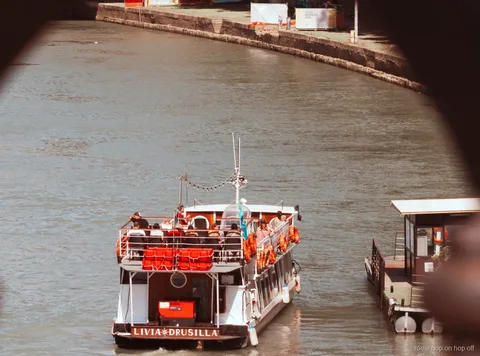 Tiber Hop-On-Hop-Off-Bootsfahrt Rom fährt unter einer historischen Brücke hindurch